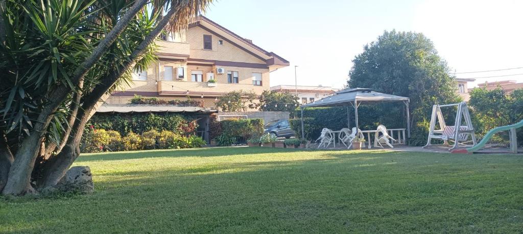 a yard with a gazebo and a swing at Residence Speedy in Fiumicino