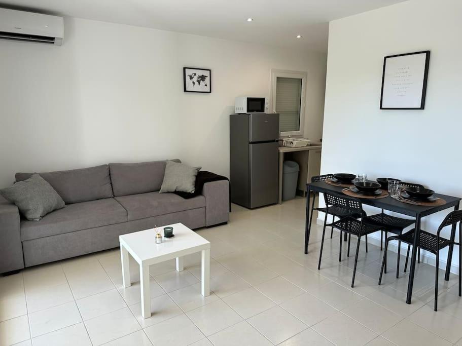 uma sala de estar com um sofá e uma mesa em Appartement en résidence em La Ciotat