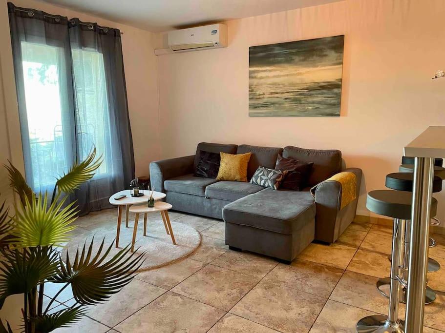 a living room with a couch and a table at Casarella Bulle de Paix en Corse Entre Terre et Mer in Lucciana