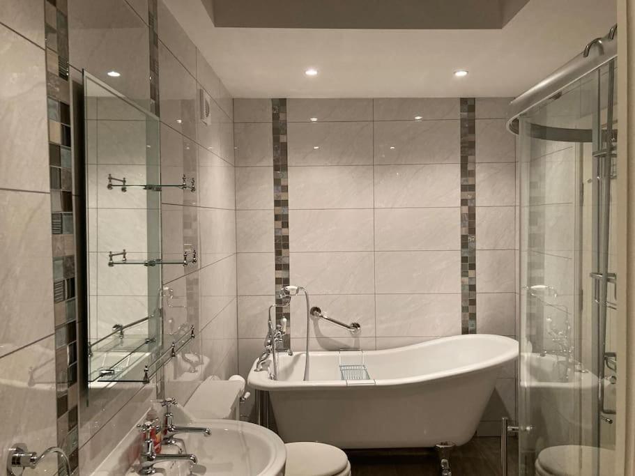 łazienka z wanną, toaletą i umywalką w obiekcie 2 Quay Road, Killala. Stunning Sea Front Cottage w mieście Killala