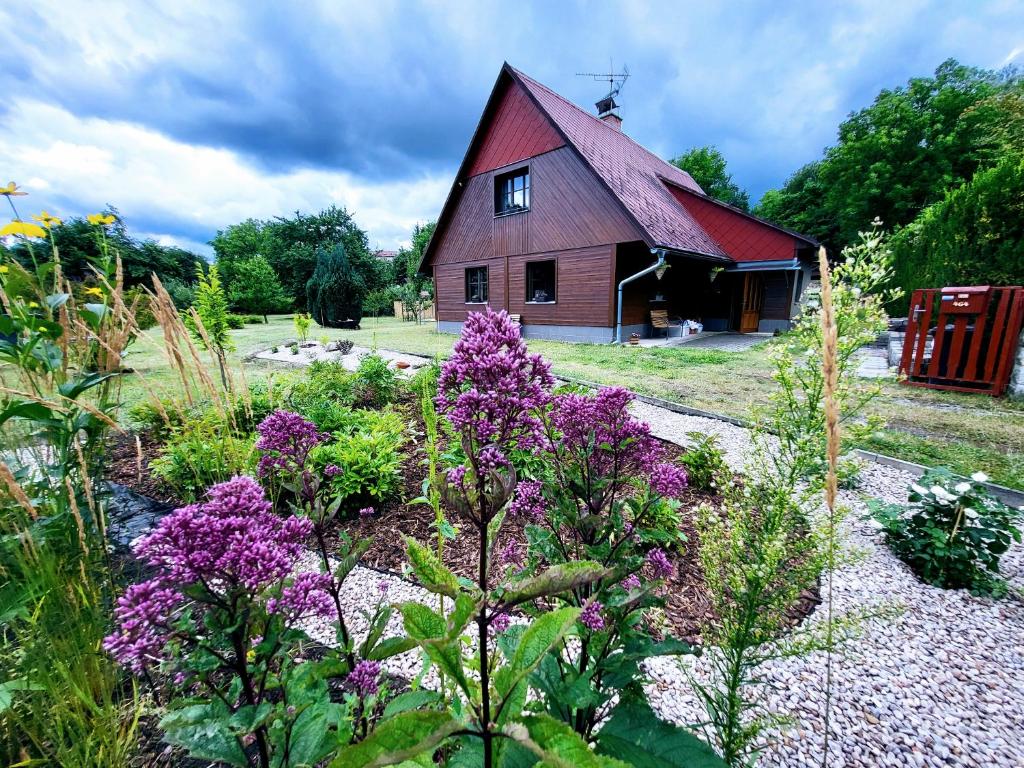 um jardim com flores roxas em frente a uma casa em Apartmán v podzámčí em Rychnov nad Kněžnou