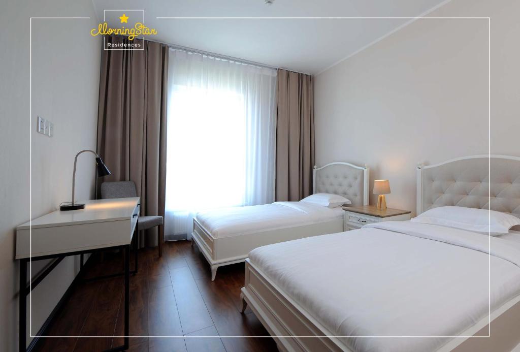 Cette chambre comprend 2 lits et une fenêtre. dans l'établissement Morning Star Residences Ulaanbaatar, à Oulan-Bator