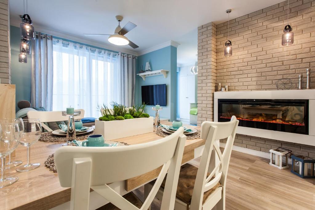 une salle à manger avec une table et une cheminée dans l'établissement Apartament MUSZELKA na Solnej 11 z garażem, à Kołobrzeg