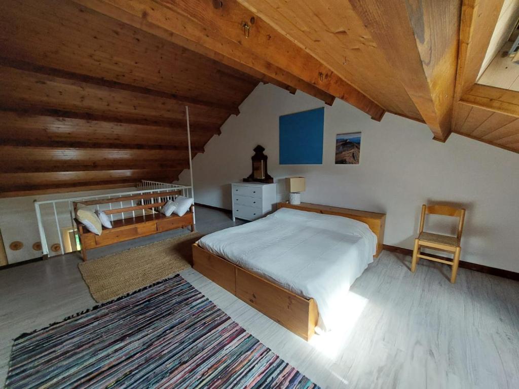 a bedroom with a bed and a chair in a attic at Lago Ballano 