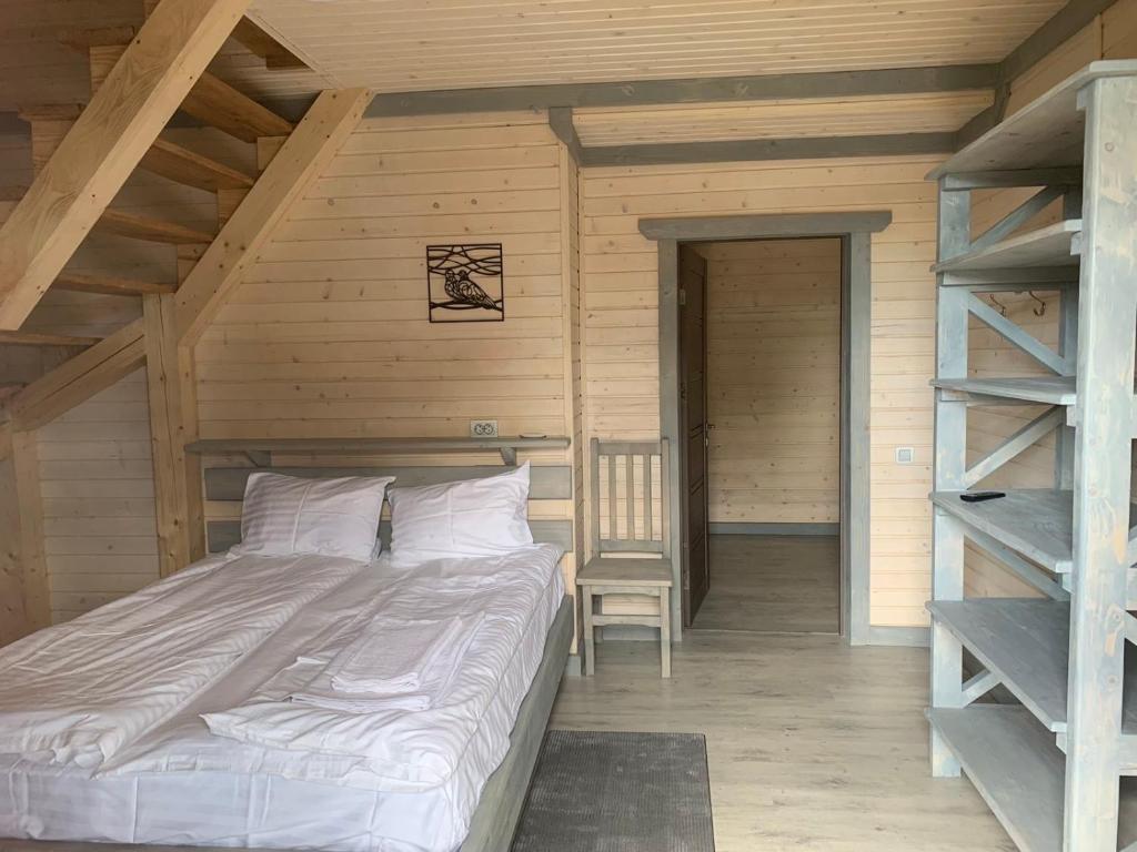 a bed in a wooden room with a ladder at Чорногора in Vorokhta