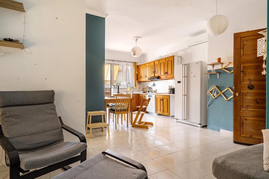 a living room with a chair and a kitchen at Nice central family apartment in Gastoúni