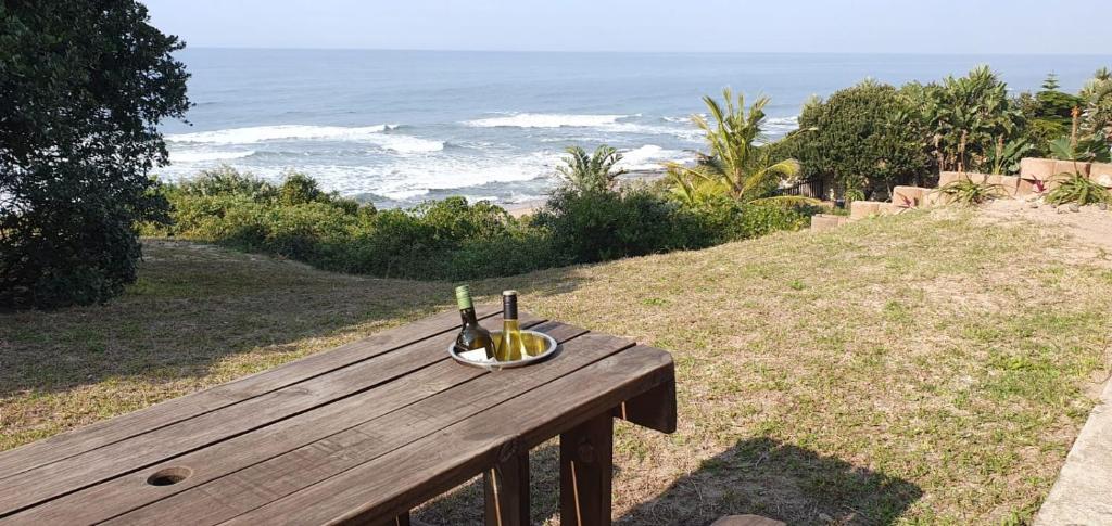 a wooden bench with a bottle of wine and a glass at Sea Escape in Sea Park