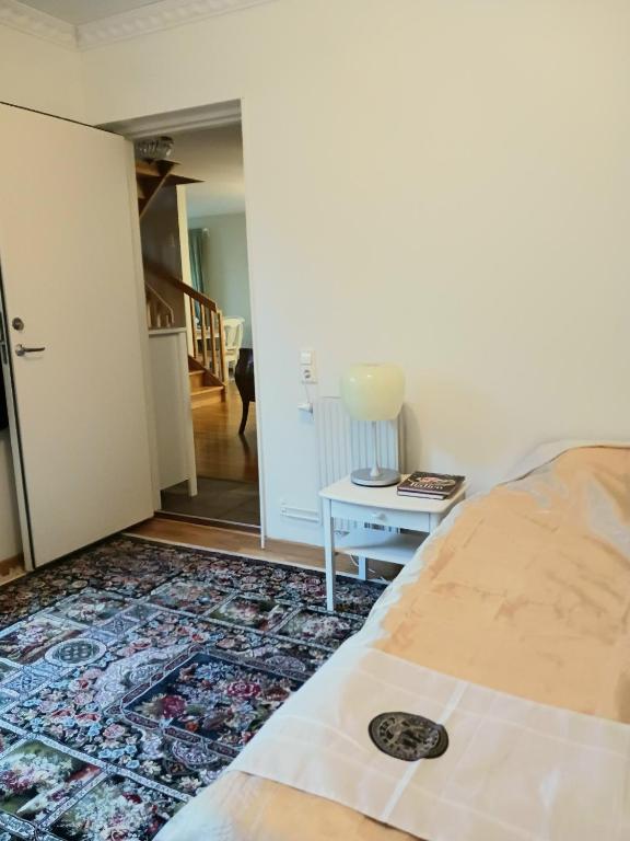 a bedroom with a bed and a table with a rug at Villa Herrhagen in Uppsala