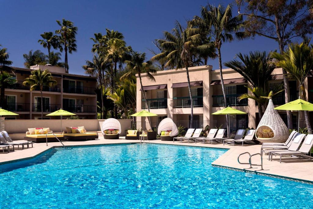 una piscina en un hotel con sillas y sombrillas en Hyatt Regency Newport Beach en Newport Beach
