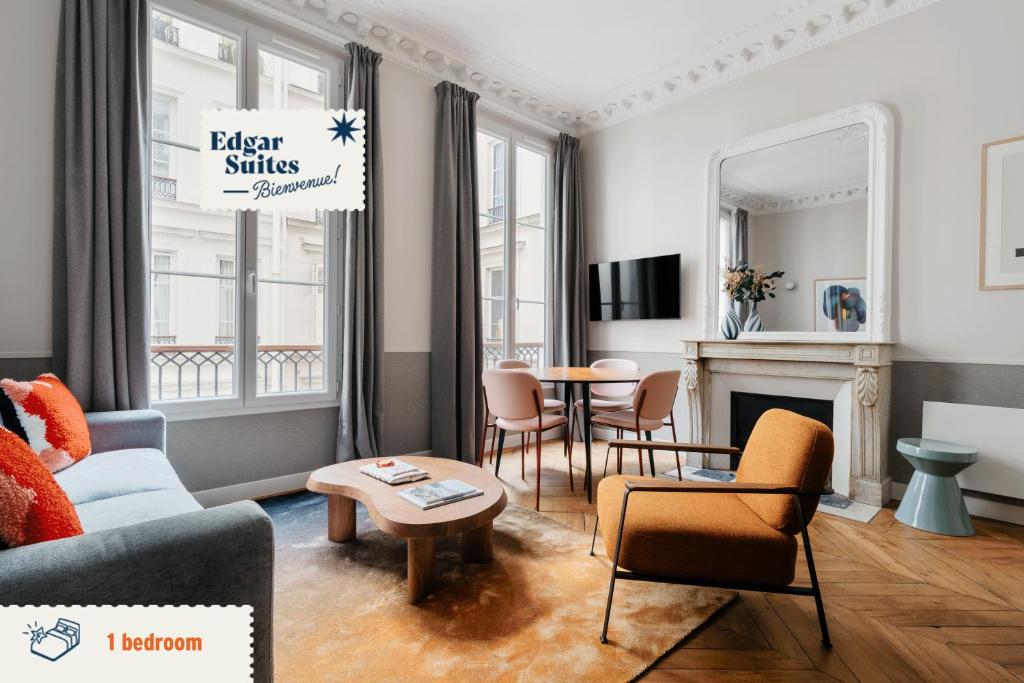 sala de estar con sofá, sillas y mesa en Edgar Suites Saint-Lazare - Amsterdam, en París