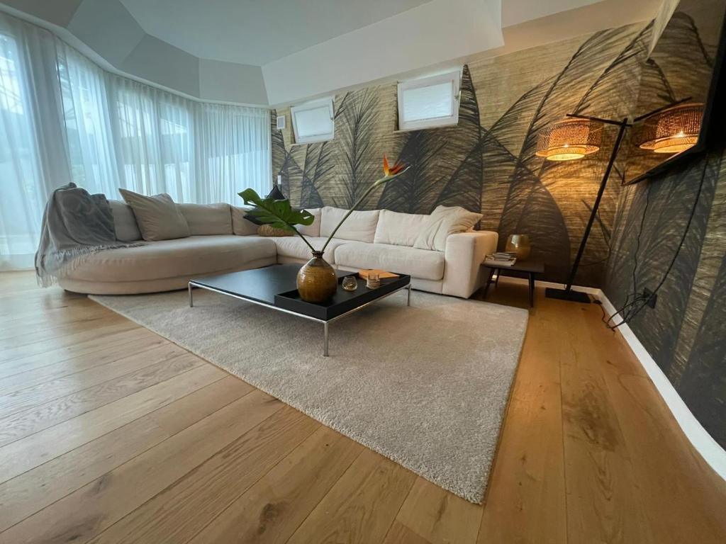 a living room with a couch and a table at Luxuriöses Loft mit großer Sonnenterrasse & Sauna in Munich
