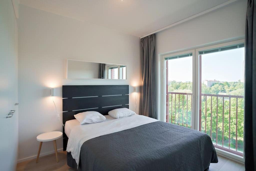 - une chambre avec un lit et une grande fenêtre dans l'établissement Norden Homes 2-Bedroom Apartment, à Turku