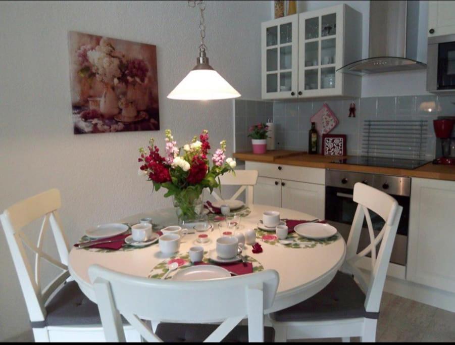 a kitchen with a table with a vase of flowers on it at Lodge 2 Bad Harzburg in Bad Harzburg