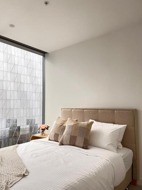 sypialnia z dużym łóżkiem i dużym oknem w obiekcie Style City Apartment Living ! w Melbourne