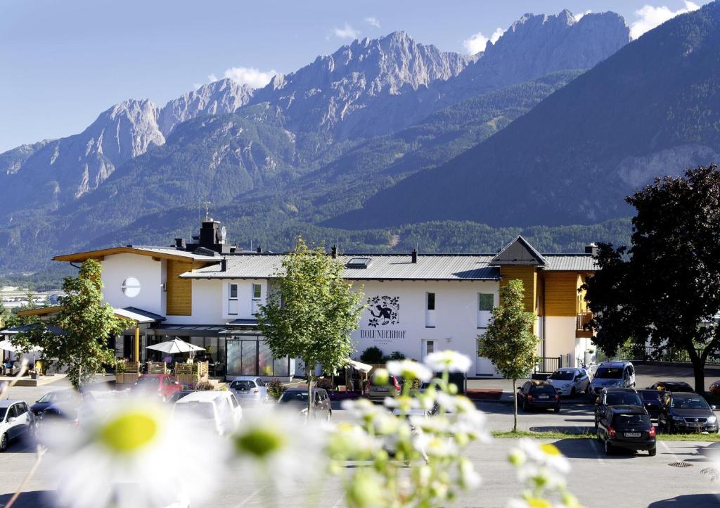 uma cidade com carros estacionados num parque de estacionamento com montanhas em Hotel Holunderhof em Lienz