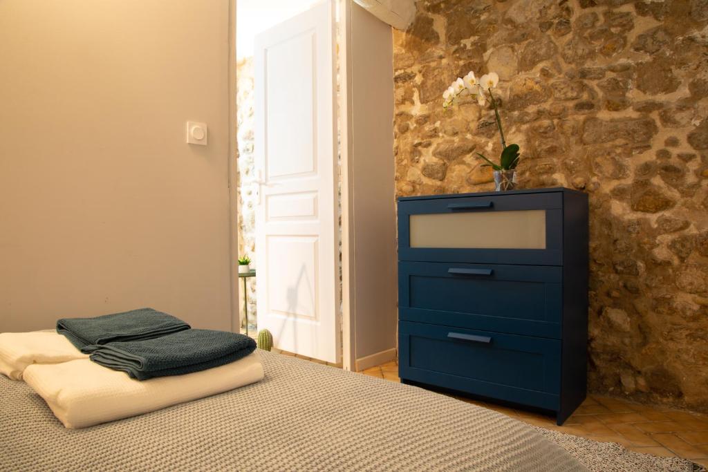 ein Schlafzimmer mit einer blauen Kommode und einem Bett mit einem Fenster in der Unterkunft Petit Studio Secret - Coeur de Provence - 4 personnes in Volx