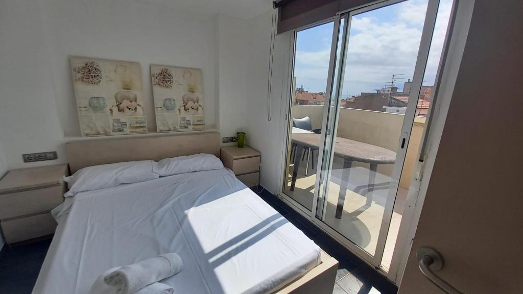 een kleine slaapkamer met een bed en een balkon bij Atico in Cambrils
