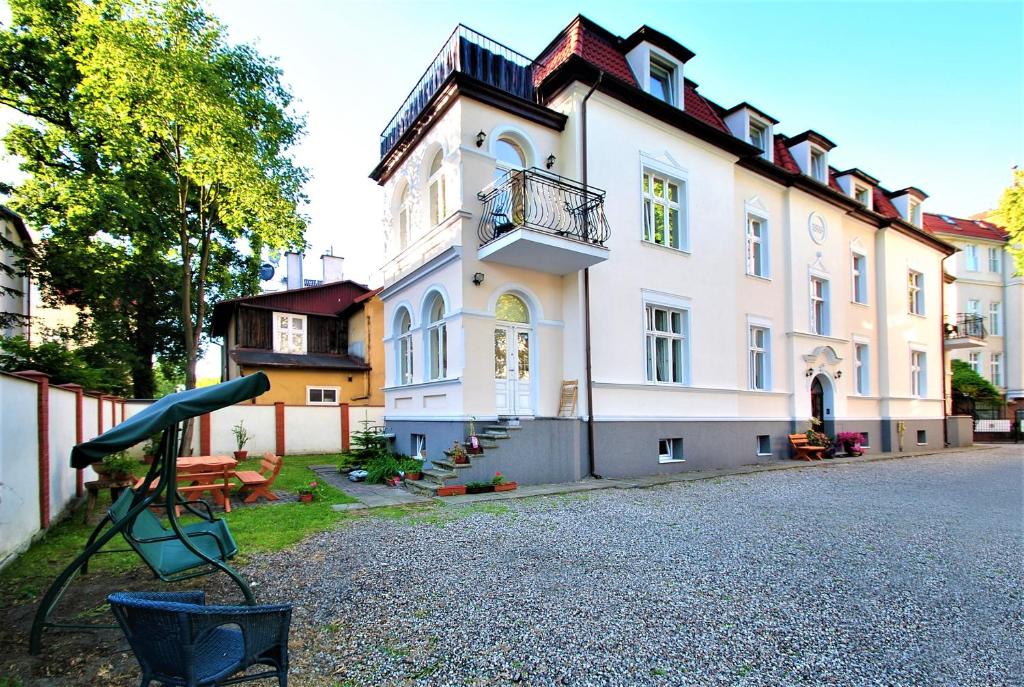 a large white building with a balcony on a street at Kamienica Ogrodowa Rooms in Sopot