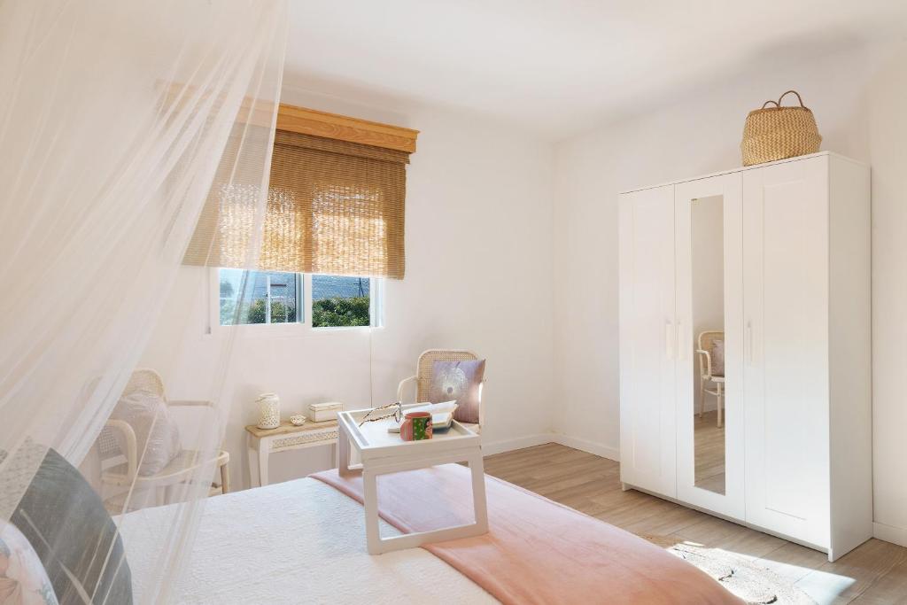 a white living room with a table and a window at Villa Tino- Casa D in Los Llanos de Aridane