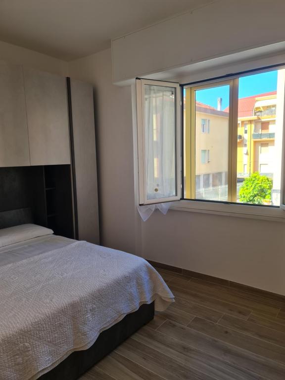 a bedroom with a bed and a large window at LOANO PERLA LIGURE in Loano