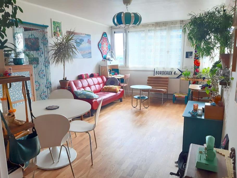 uma sala de estar com um sofá, uma mesa e cadeiras em Charmant 2 pièces, parking privé em Bagnolet