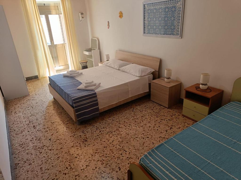 - une chambre avec un lit, deux tables et une fenêtre dans l'établissement Casa Vacanze A Due Passi dal Mare, à Portopalo di Capo Passero