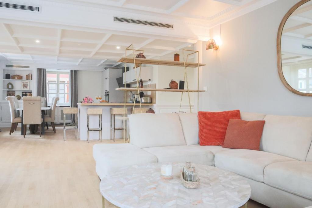 ein Wohnzimmer mit einem weißen Sofa und einem Tisch in der Unterkunft Le Tropical, Chic & Design in Wahlbach
