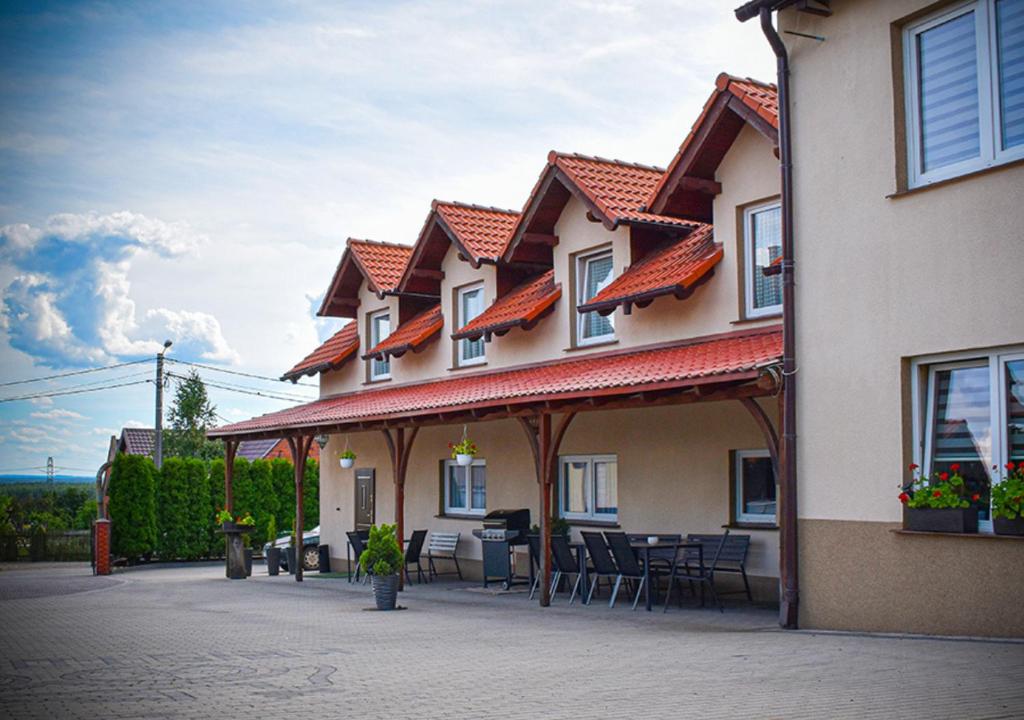 a building with a patio with tables and chairs at Hostel Sadowianka in Ostrów Wielkopolski