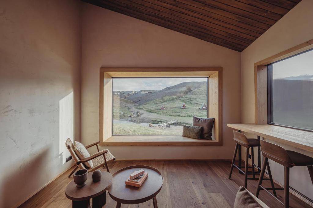 Zimmer mit einem großen Fenster mit einem Tisch und Stühlen in der Unterkunft Highland Base Kerlingarfjöll in Kerlingarfjoll