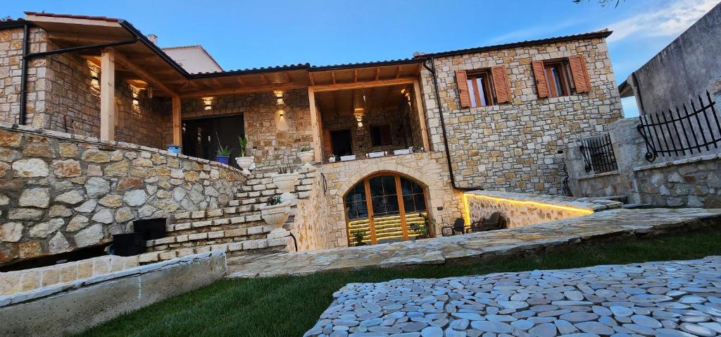 a brick house with a stone wall at Vila 369 Dhermi in Dhërmi