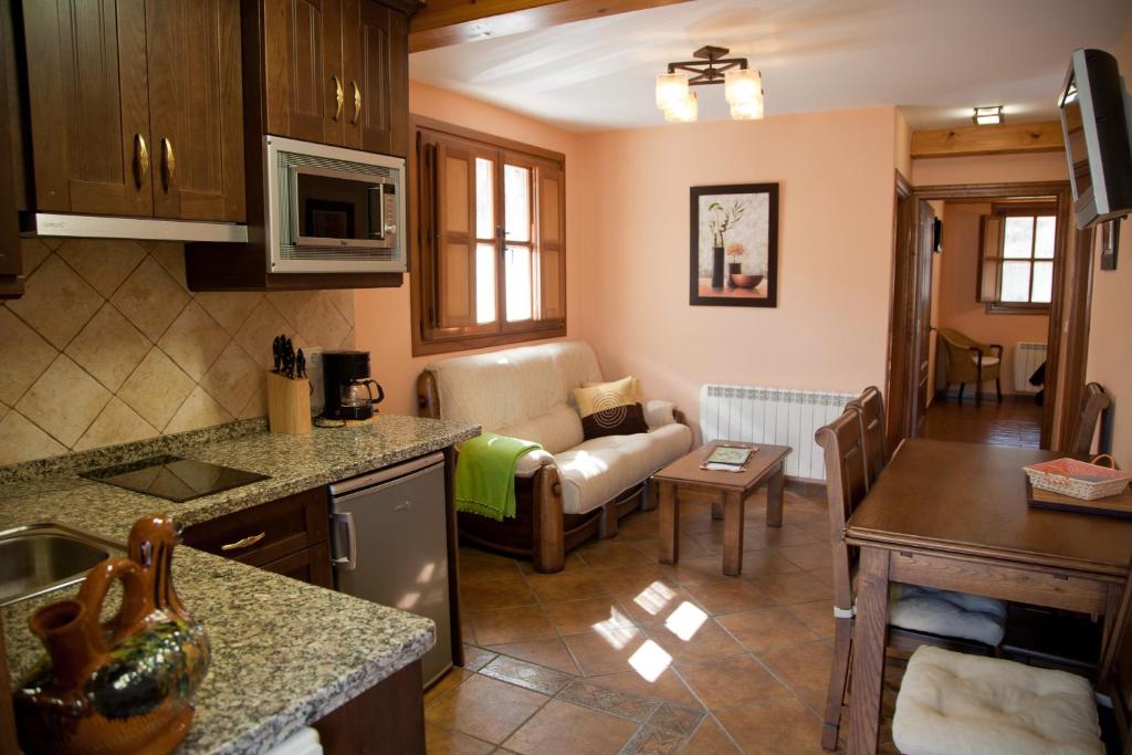 cocina y sala de estar con sofá en Apartamentos Valdecarzana Senda del Oso, en San Martín