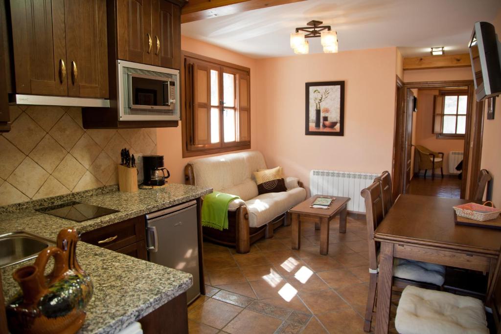 a kitchen and a living room with a couch at Apartamentos Valdecarzana Senda del Oso in San Martín