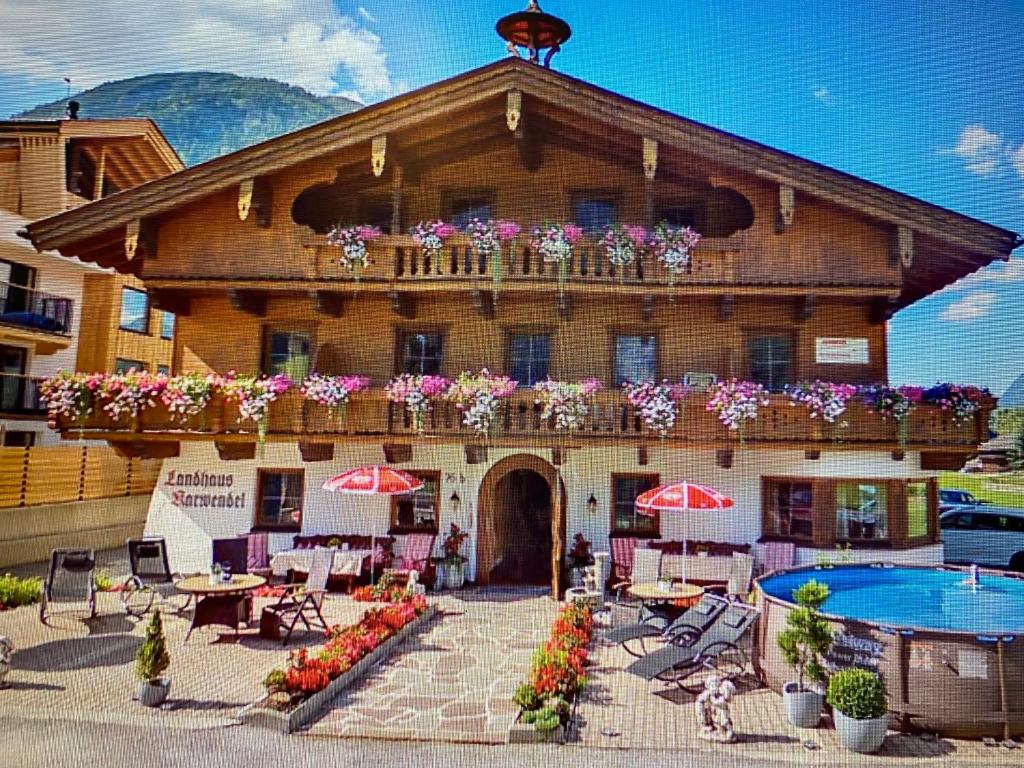 a building with a swimming pool and a house with flowers at Appartement Frühstückspension Landhaus Karwendel in Pertisau