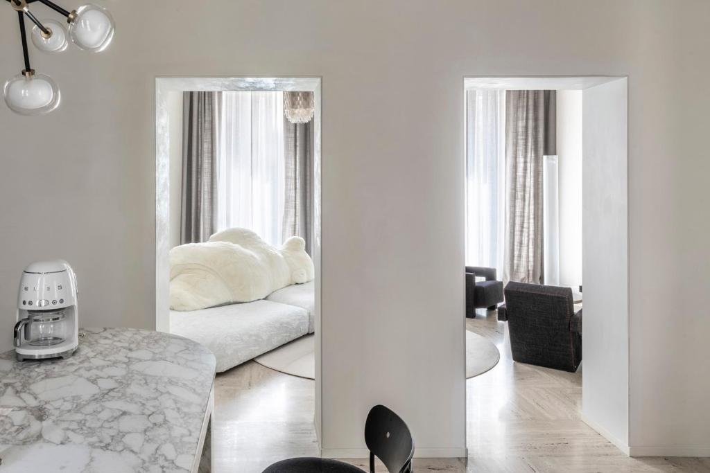 a living room with a white couch and a mirror at Luxe Rome apartment in Rome