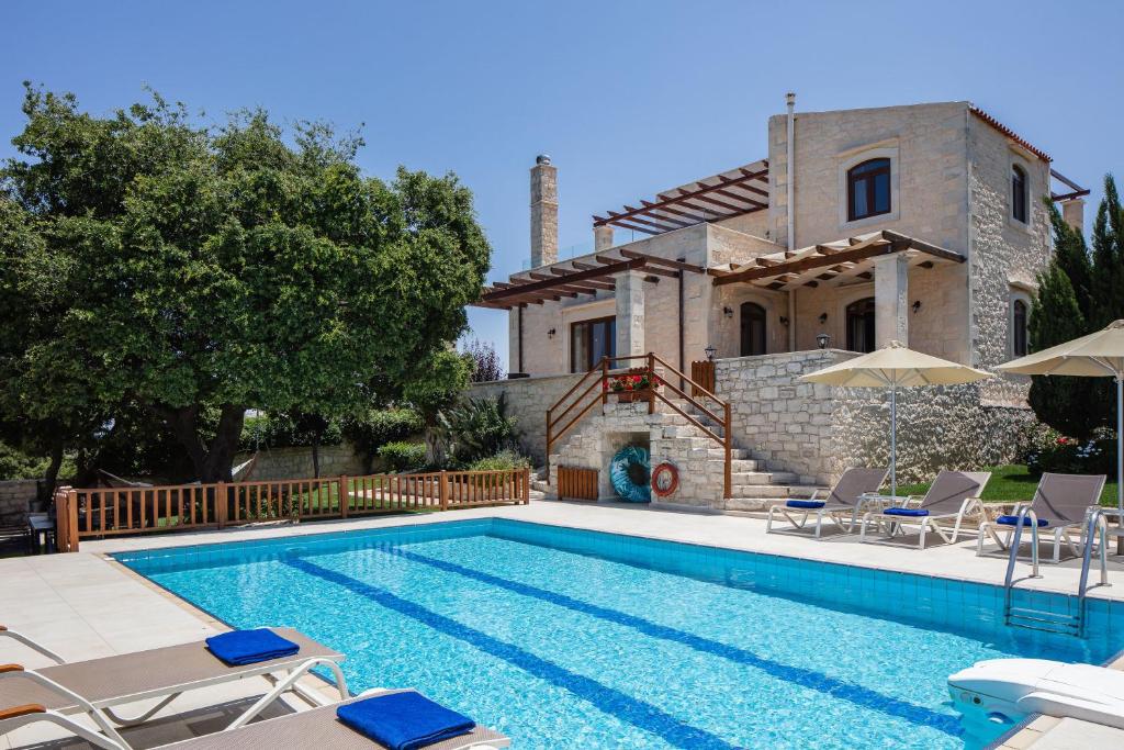 a villa with a swimming pool and a house at Villa Eleftherna in Elefterna