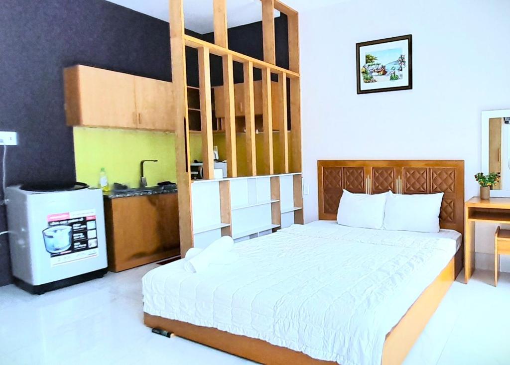 een slaapkamer met een bed en een keuken met een fornuis bij Love Hotel & Apartments in Vung Tau