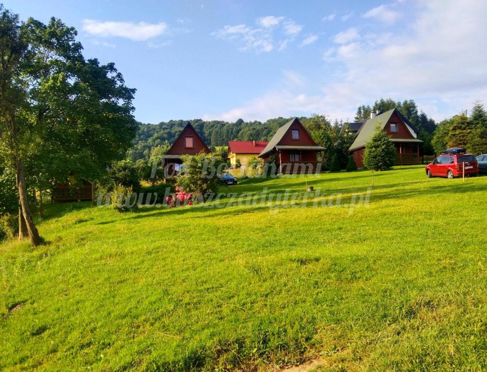 波蘭茲克的住宿－Agroturystyka Pod Bocianami Terka，一片绿草丛,有房子的背景
