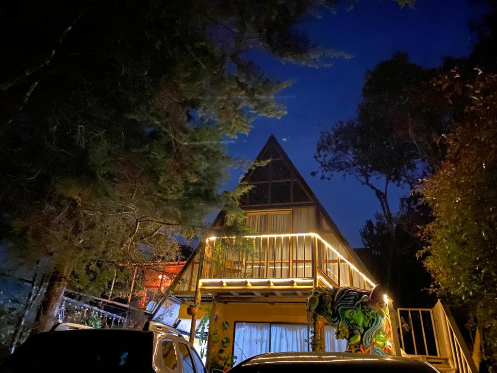 a house with lights on the side of it at night at ALTEA triángulo con jacuzzi, Santa Elena in Medellín