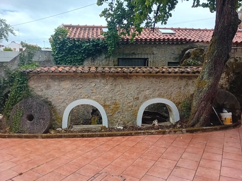 an old stone house with a tree in front of it at Retiro d'Azenha in Almoster
