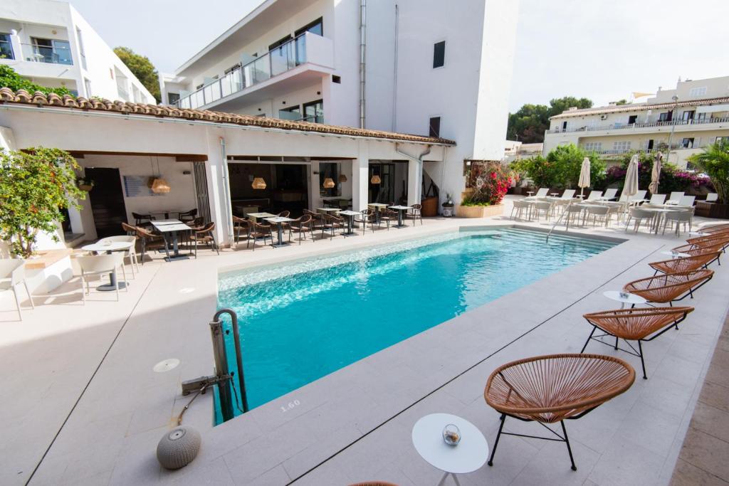 a pool at a hotel with chairs and tables at Petit Garden Hotel by Flacalco in Cala Ratjada