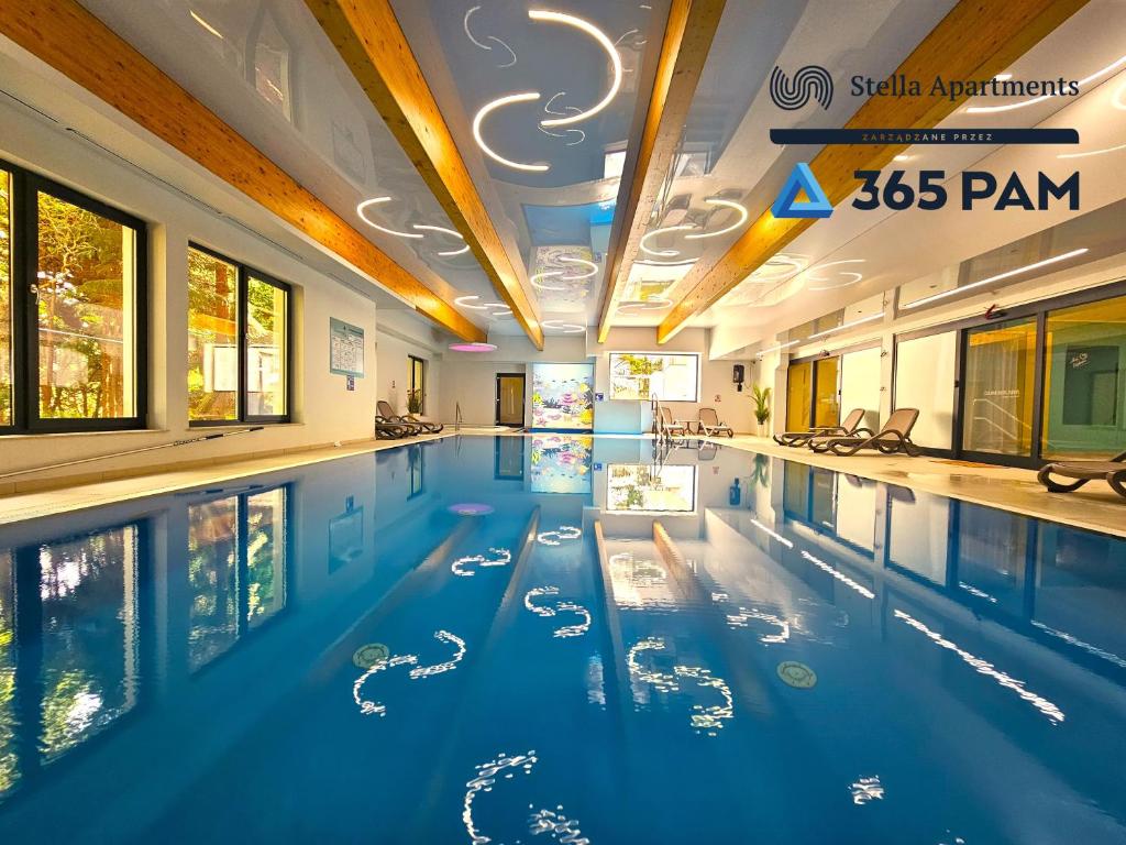 una gran piscina de agua azul en un edificio en Dominikana Studio Apartamenty - 365PAM, en Sianożęty