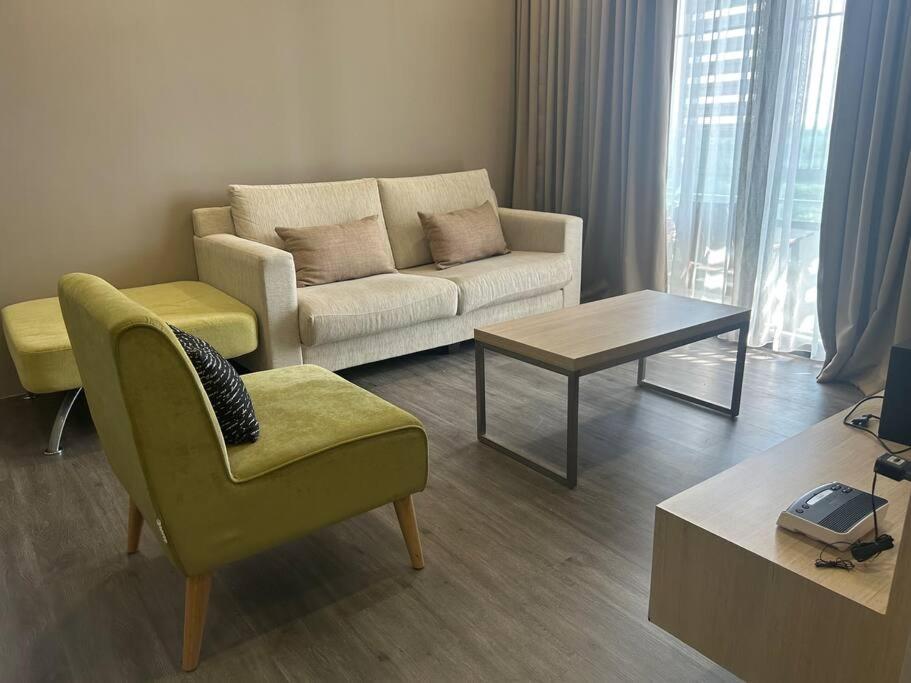 ein Wohnzimmer mit einem Sofa und einem Tisch in der Unterkunft Amy*USS@The Springs Mall in Kuching