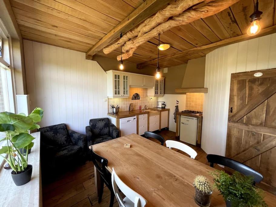 een keuken en eetkamer met een houten tafel bij Woonboerderij Markelo in Markelo
