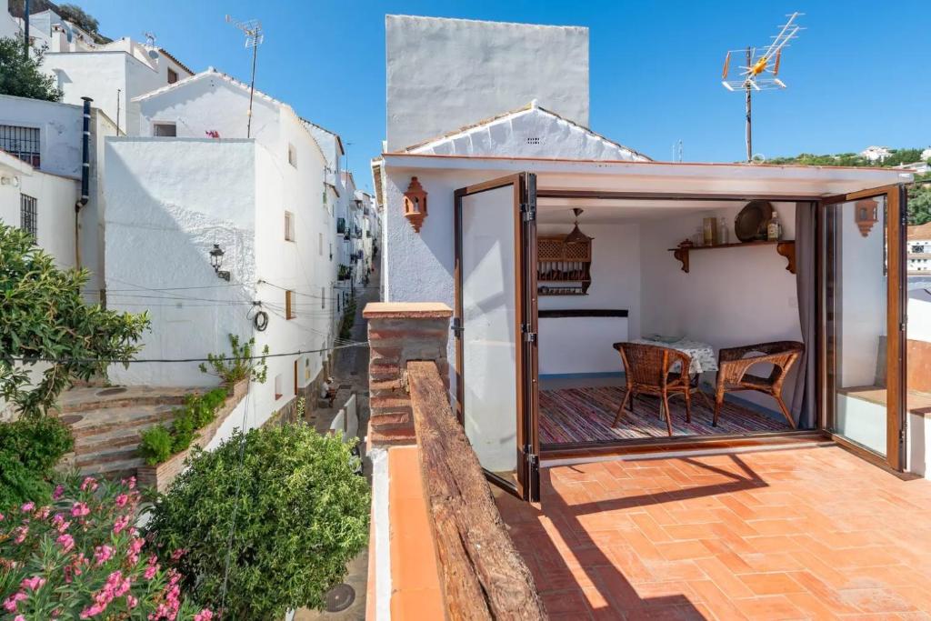 mały dom ze szklanymi drzwiami na patio w obiekcie La casita de Casares w mieście Casares