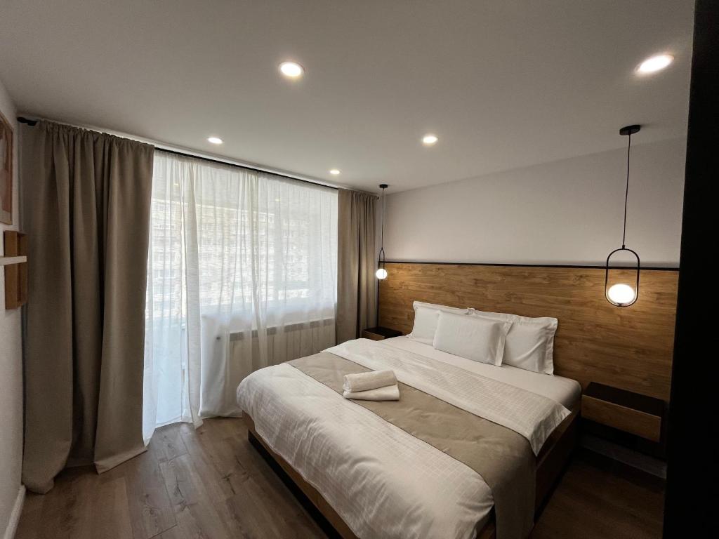 ein Schlafzimmer mit einem großen Bett und einem großen Fenster in der Unterkunft CentralLuxuryAptHotel in Piatra Neamţ
