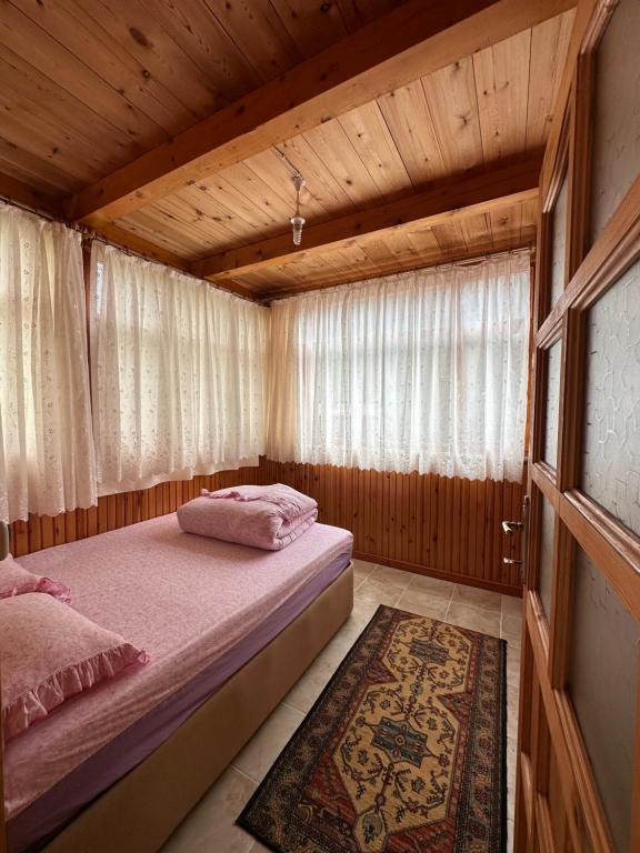 a bedroom with a bed in a wooden house at İnka Apart House in Ayder Yaylasi