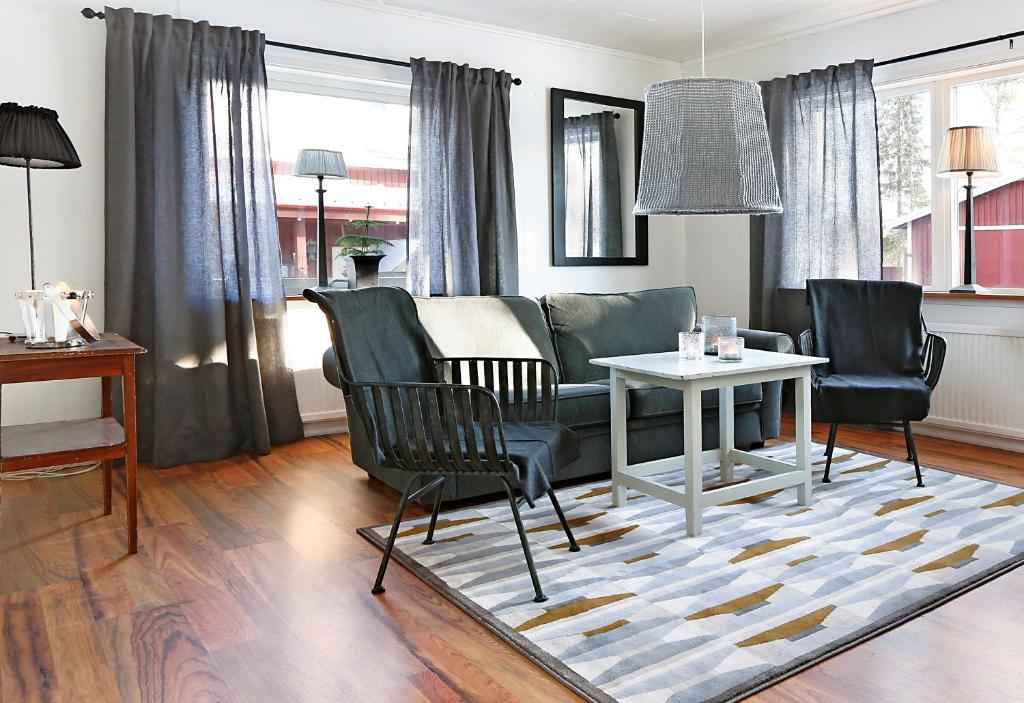 - un salon avec un canapé, des chaises et une table dans l'établissement Kallaxgårdshotel/apartment, Luleå, à Luleå