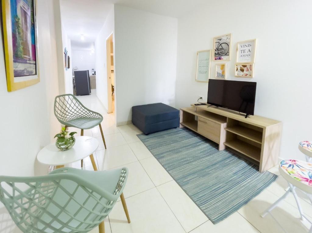 a living room with a tv and chairs at 2 bedroom apartment 2CB-3 in Getsemani in Cartagena de Indias