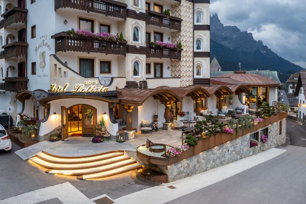 a large building with a fountain in front of it at Hotel Letizia in San Martino di Castrozza
