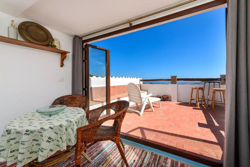 Pokój ze stołem i krzesłami oraz balkonem w obiekcie La casita de Casares w mieście Casares